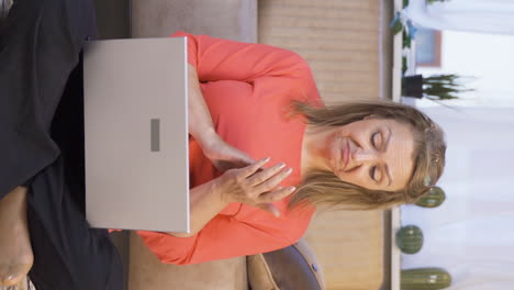Vertical-video-of-Woman-looking-at-laptop-applauding.